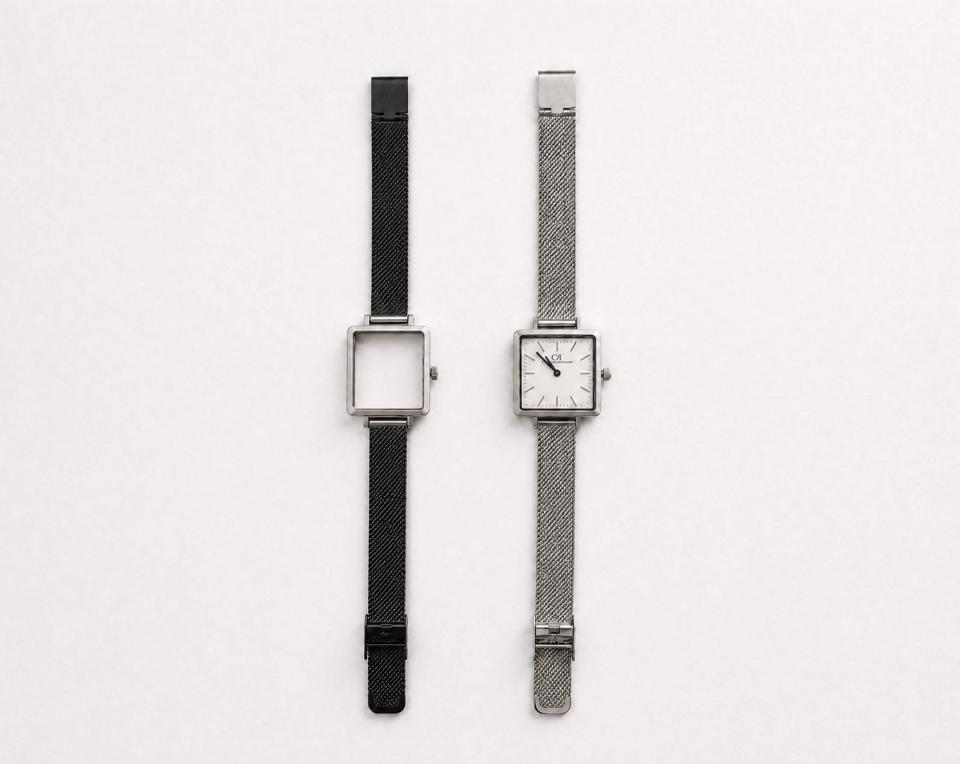 Aureum Swiss Made modular watch — square silver case with white dial and silver mesh strap, shown alongside black case with black mesh strap